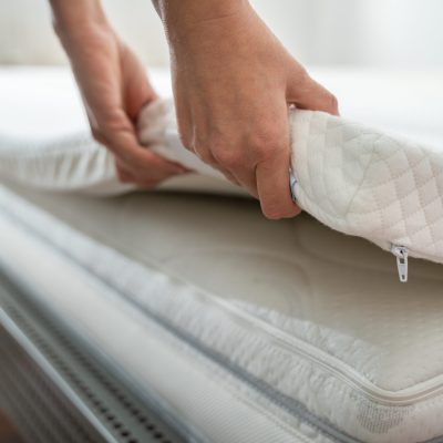 Mattress Topper Being Laid On Top Of The Bed