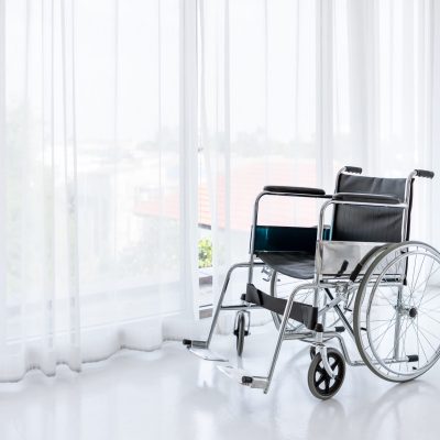 Wheelchair in empty room in nursing home or hospital